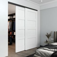 an open closet door in a bedroom next to a bed