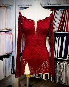 a mannequin in front of a red lace dress