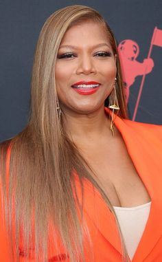 queen latifah at the american music awards in an orange dress and gold earrings