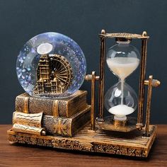 an antique clock and hourglass sitting on top of a wooden table next to each other