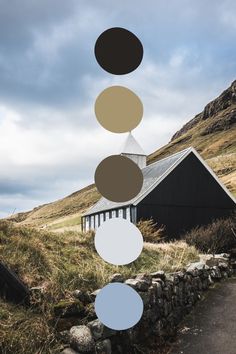 an image of a house in the mountains with circles hanging from it's roof