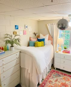 a bed room with a neatly made bed next to a dresser and a rug on the floor