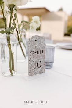 there is a table with flowers in vases and a sign that says table 10