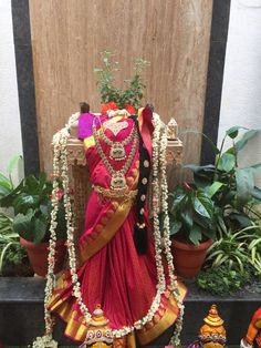 an idol is displayed in front of some potted plants