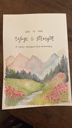 a greeting card with watercolor painting of mountains and trees on it, says god is our refuge & strength