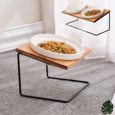 a bowl of food sitting on top of a wooden table next to two white plates