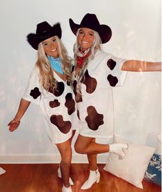 two women dressed up in costumes posing for a photo while wearing cowboy hats and holding their arms out