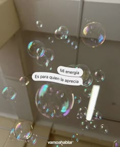 soap bubbles floating in the air next to a bathroom door with spanish words written on them