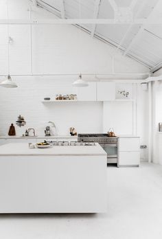 a large white kitchen with an island in the middle