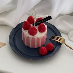 a small cake with raspberries is on a plate