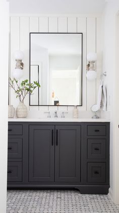 a white and black bathroom with two sinks