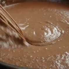 a wooden spoon stirring chocolate in a pot