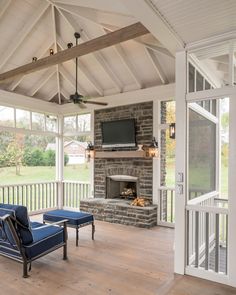 an outdoor living room with a fireplace and television