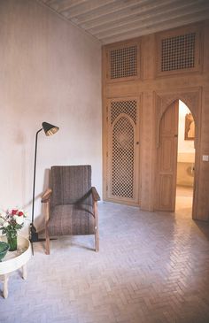 a chair and table in a room with wood paneled doors on either side of the wall