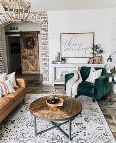 a living room with two couches and a coffee table in front of a brick wall