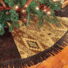 a christmas tree with lights on it in front of a rug and wooden flooring