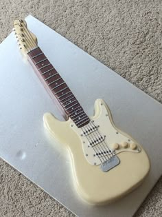 a cake shaped like an electric guitar sitting on top of a sheet of frosting