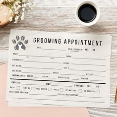 a grooming appointment card on top of a desk next to a cup of coffee