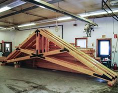 a large wooden structure sitting in the middle of a room with other items around it