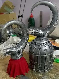 a metal tea pot with a dragon handle on it's side sitting on a table