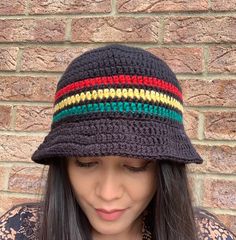 a woman wearing a black crocheted hat with multicolored stripes on it