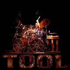 the drummer is on stage with his drums in front of him and says toot