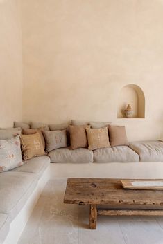 a living room filled with lots of furniture and pillows on top of a wooden table