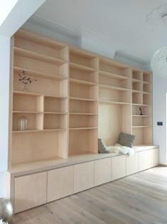 an empty room with wooden shelves and white walls