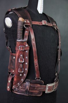 a mannequin's back with leather straps and metal buckles on it