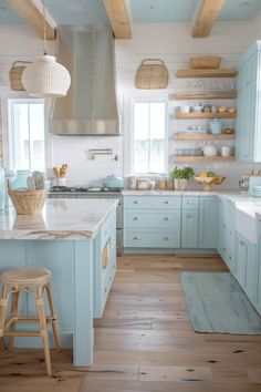 a kitchen with blue cabinets and white counter tops, wooden flooring and open shelves