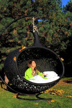 a woman is sitting in a hanging chair