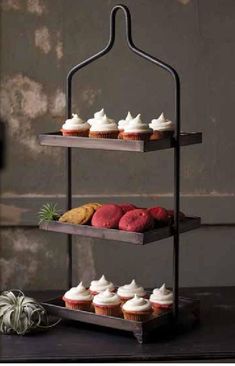 three tiered tray with cupcakes on it