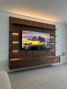 a flat screen tv mounted to the side of a wooden entertainment center in a living room