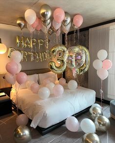 a bedroom decorated with balloons and streamers in the shape of numbers for 30th birthday