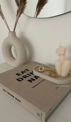 a book sitting on top of a table next to a vase