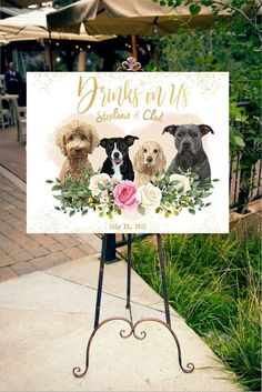 a sign with three dogs on it and flowers in front of the sign is an easel