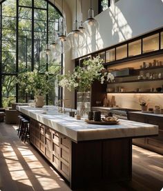 a large kitchen with lots of counter space and glass doors on the windowsills