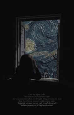 a person sitting in front of a window looking out at the starry night sky