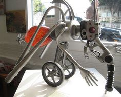 an unusual looking sculpture is on display in a room with cars parked outside the window