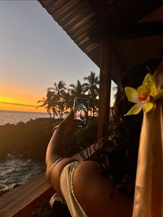 a woman taking a photo with her cell phone on the beach at sunset or sunrise