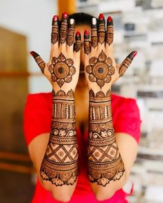 a woman's hands with henna tattoos on them