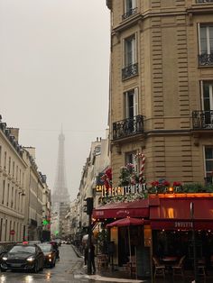 the eiffel tower is seen in the distance from an empty street with cars parked on both sides