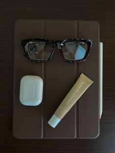 a pair of glasses sitting on top of a table next to a tube of toothpaste