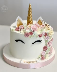 a cake decorated with flowers and an unicorn's face