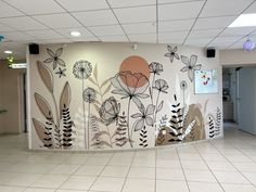 an office lobby with flowers painted on the wall and tile flooring in front of it