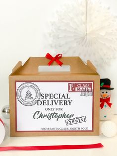 a box that is sitting on a table with christmas decorations around it and the words special delivery only for cupcakes from santa clause north pole