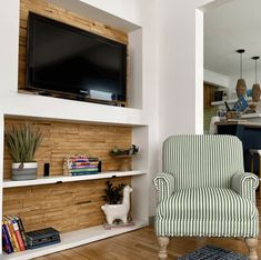 a living room filled with furniture and a flat screen tv mounted on the wall above it