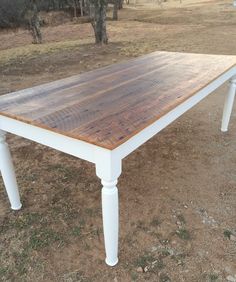 a wooden table sitting on top of a dirt field