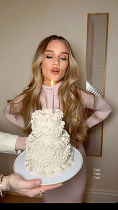 a woman holding a cake with a candle in it