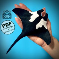 a hand holding a black and white mask with an origami bird on it